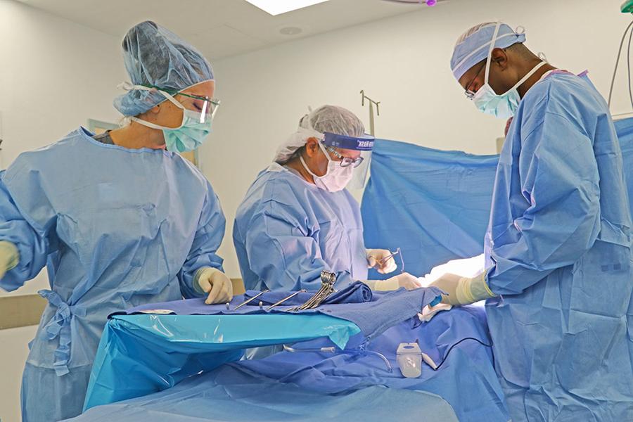 学生外科技术员在健康科学模拟中心的一间手术室进行模拟手术