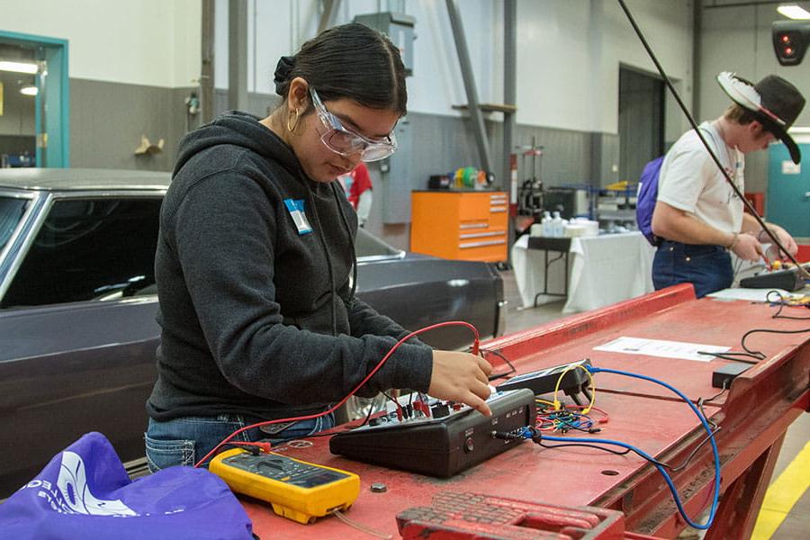 Two San Juan College students using diagnostic tools in the automotive repair shop